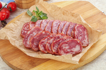 Sliced salami sausages over board