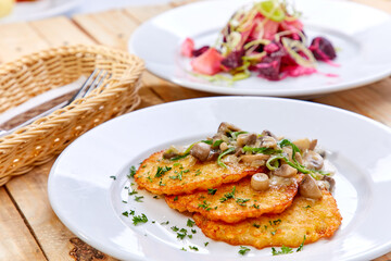 potato pancakes with sauce and mushrooms