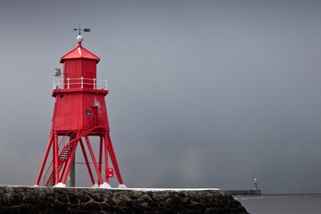 A Red Lighthouse Under A Stormy Sky Along The Coast; South Shields, Tyne And Wear, England