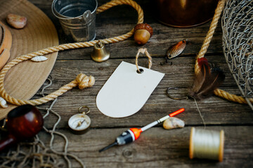 Fishing theme. Round label with hooks, bucket, fishing buoy, compass and fish string on wooden...