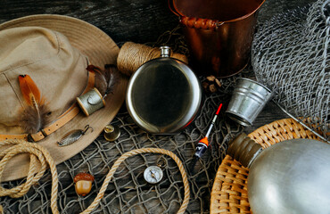 Metal flask with place for text or logo, lay on net and old wood table. fishing background