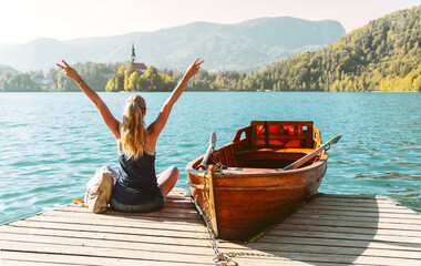 Happy female tourist with open arms enjoying view of lake bled in Slovenia