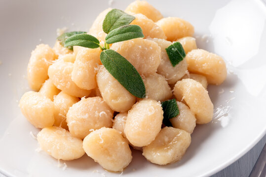 Piatto di deliziosi gnocchi di patate conditi con burro e salvia, cibo italiano 