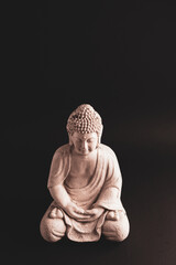 White sitting Buddha statue. Smooth background. Lotos position. 