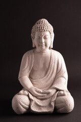 White sitting Buddha statue. Smooth background. Lotos position. 