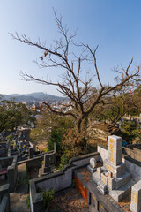 NAGASAKI, JAPAN: Sakamoto International Cemetery and elevated view on the city, many western expats who came to Japan for business in the 19th century are buried here