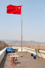 TUMEN, CHINA: China-North Korea Friendship Monument observation deck, with Chinese flag and North Korea in the background, accross the Tumen River