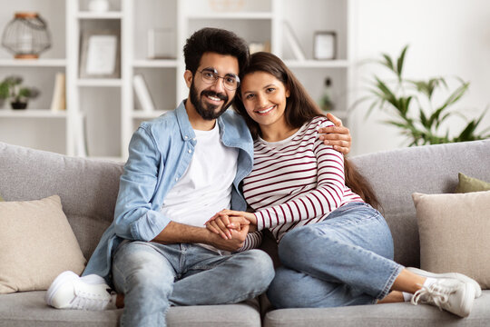 Loving eastern millennial man and woman cuddling at home