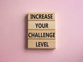 Challenge Level symbol. Concept word Increase your Challenge Level on wooden blocks. Beautiful pink background. Business and Increase your Challenge Level concept. Copy space