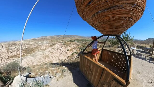 Tourist girl at Devrent Valley top view in Cappadocia, Turkey on an air balloon. From Devrent Lookout, you can marvel at geological wonders sculpted by nature's artistic forces over millions of years.