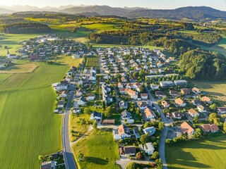 Aerial view of rural village in morning sunlight in Switzerland. Housing development in rural area.