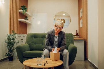 An anxious senior woman is contemplating during a session with a psychotherapist