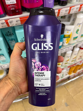 Close up view of a hand holding famous shampoo brand's package in supermarket