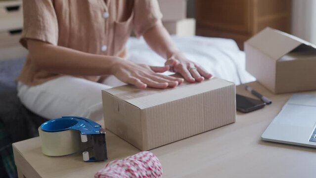 Business owner entrepreneur packing cardboard box preparing parcel for shipment, Online marketing..