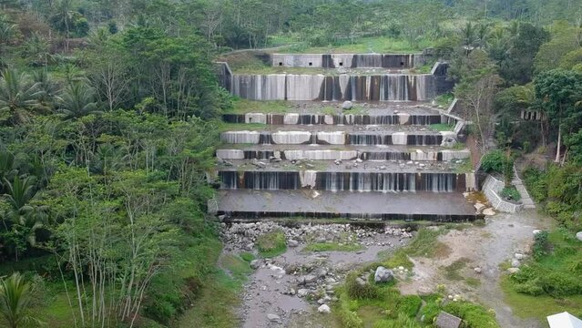 Aerial footage of the Watu Purbo sabo dam in Sleman, Indonesia which has a 6-level water dam. Apart from preventing the eruption of Mount Merapi, this dam is also a popular tourist destination