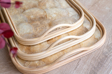 trays made of mother of pearl discs on wood background.