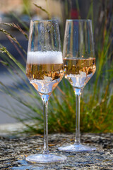 Tasting of premier cru sparkling rose wine with bubbles champagne with view on old houses of Hautvillers, where lived Benedictine monk how developed champagne wine, France.