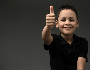 boy with thumbs up gesture on grey background with people stock photo