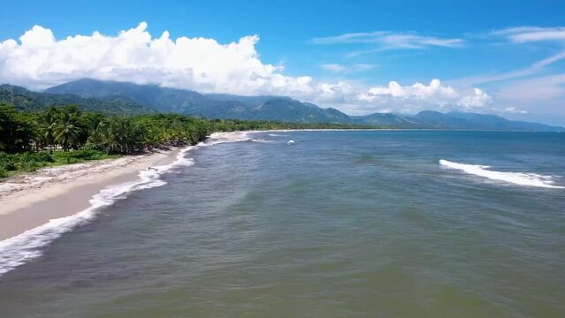 Hyperlapse Drone Footage of Tropical Coastline Journey &ndash; Soaring Over Palm Trees and Rugged Mountains on the Left, Azure Sea Stretching to the Horizon on the Right