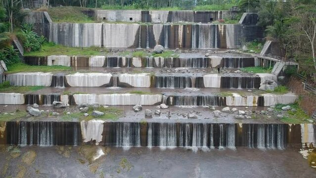 Aerial footage of the Watu Purbo sabo dam in Sleman, Indonesia which has a 6-level water dam. Apart from preventing the eruption of Mount Merapi, this dam is also a popular tourist destination