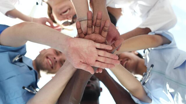 Low Angle View Of Doctor Stacking Hands Together In Hospital