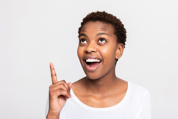 Happy surprised excited african american woman female looking good wearing casual white shirt...