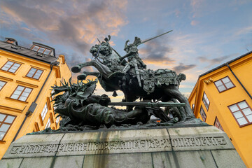 Sunset view from below of the Saint George and the Dragon sculpture in Köpmantorget, or Merchants' Street in the medieval Gamla stan district, Stockholm, Sweden. - obrazy, fototapety, plakaty