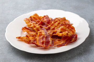 Delicious fried bacon served on plate.
