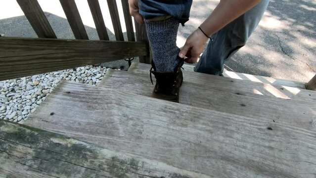 woman putting on work shoes before working in the garden