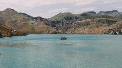 Aerial view boat with tourists sailing on the reservoir Green Canyon Turkey .