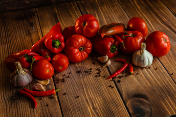 Red tomatoes and peppers on wooden table