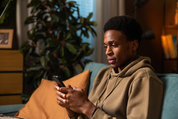 Dark skinned African American dark skinned professional using his phone to stay on top of work...