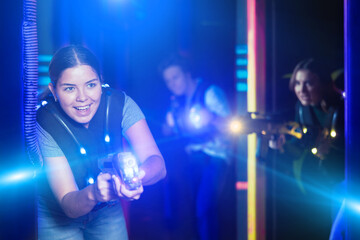 Girl running and dodging while playing lasertag