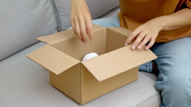 shopping addicted woman unboxing new parcel with gadget headphones delight through e-commerce and rapid express online shopping.