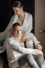 Sensual and tender morning of the bride and groom in the hotel room. Confident girl bride and handsome boy groom. Preparation for the wedding