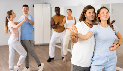 Adult man and adult woman dancing pair dance in dance hall