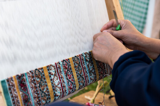 Carpet weaving using traditional techniques on a loom. , close-up of weaving and handmade carpet production.