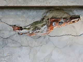 Close up a fragment of the old brick wall with falling plaster on a sunny spring day, Lodz, Poland.