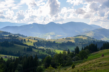 Panorama of green foothills with forests and meadows in bright green colors. Beautiful landscape...