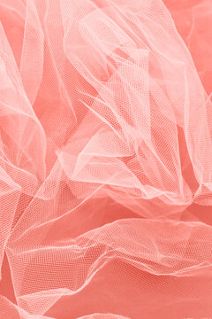Crumpled veiling cloth on coral background