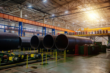 Modern seam pipe factory production line. New manufactured pipes on roller conveyor