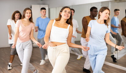 Fototapeta premium Dance class for adult people, positive women and men training in studio