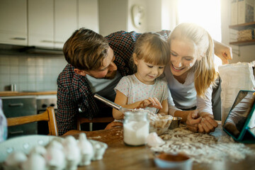 Young family baking together and having fun while being messy in the kitchen