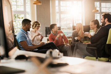 Young and diverse group of people having coffee and relaxing after work in the marketing company...