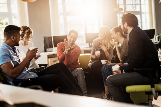 Young and diverse group of people having coffee and relaxing after work in the marketing company office