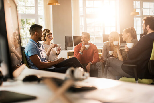 Young and diverse group of people having coffee and relaxing after work in the marketing company office - Powered by Adobe