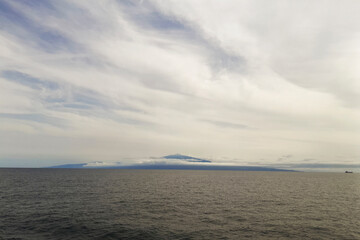 Seascape. View of Cameroon Mountain from the Gulf of Guinea. Volcano on the horizon. Atlantic Ocean, West Africa. Clouds and water. Sailor's life.