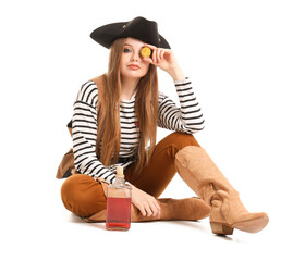 Beautiful female pirate with bottle of rum and golden coin on white background