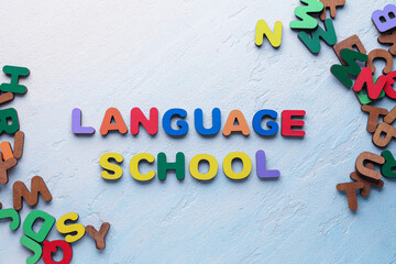 Text LANGUAGE SCHOOL and wooden letters on gradient background