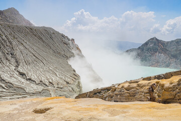 Mount Ijen Volcanic Crater blue fire and lake when day time. The photo is suitable to use for adventure content media, nature poster and forest background.